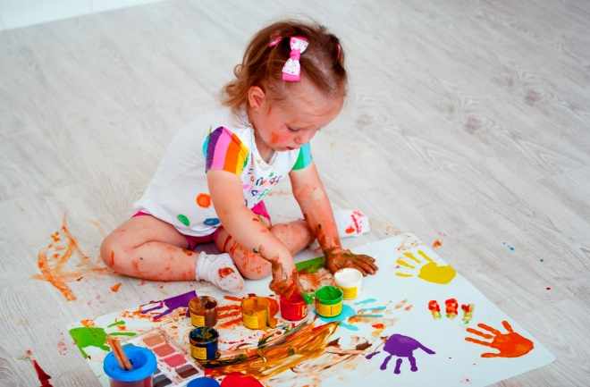 Девочка рисует пальчиковыми красками